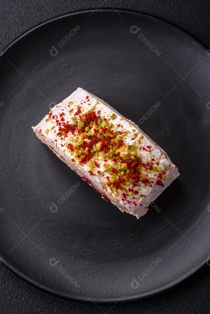 Um pedaço de delicioso rolo de merengue doce com queijo mascarpone, frutas e amêndoas