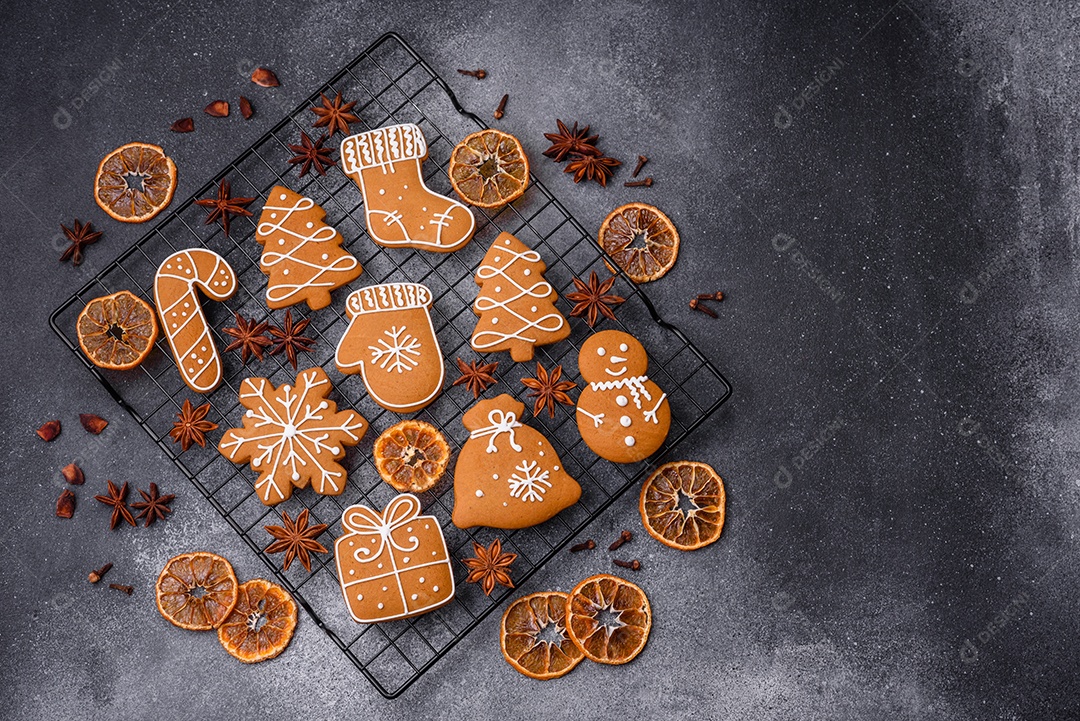 Lindos e deliciosos biscoitos de gengibre de Natal de inverno em um fundo cinza texturizado.