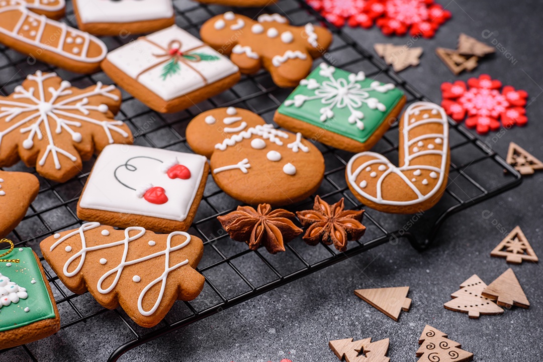 Lindos e deliciosos biscoitos de gengibre de Natal de inverno em um fundo cinza texturizado.