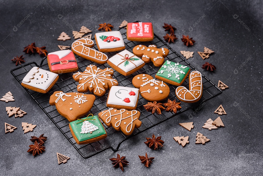 Lindos e deliciosos biscoitos de gengibre de Natal de inverno em um fundo cinza texturizado.