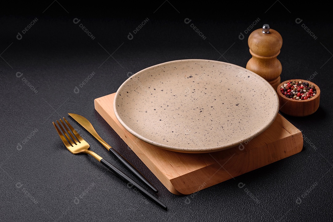 Placa cerâmica colorida vazia redonda em fundo de textura de concreto. Preparando pratos e talheres para o jantar