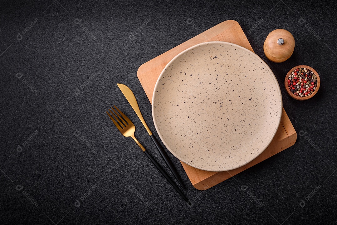 Placa cerâmica colorida vazia redonda em fundo de textura de concreto. Preparando pratos e talheres para o jantar