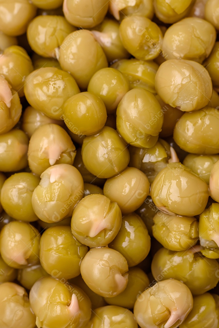 Deliciosas ervilhas enlatadas com sal e especiarias em uma tigela branca sobre um fundo escuro de concreto