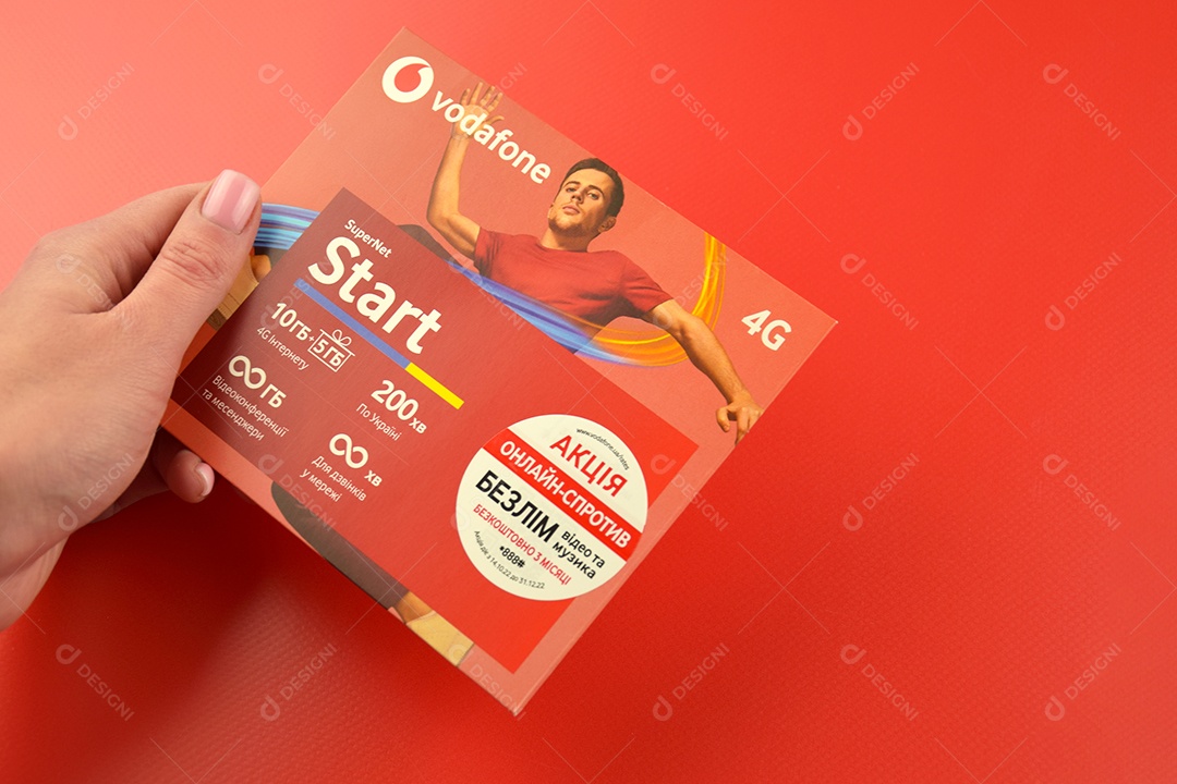 Pacote inicial da Vodafone em mão feminina sobre fundo vermelho
