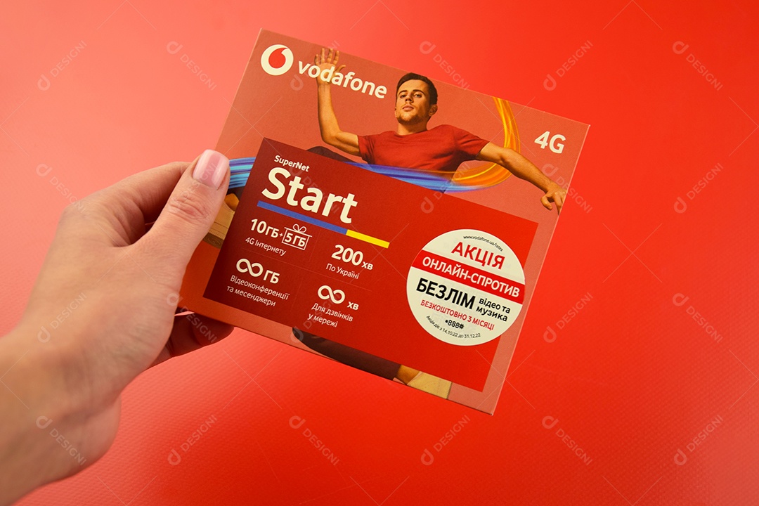 Pacote inicial da Vodafone em mão feminina sobre fundo vermelho