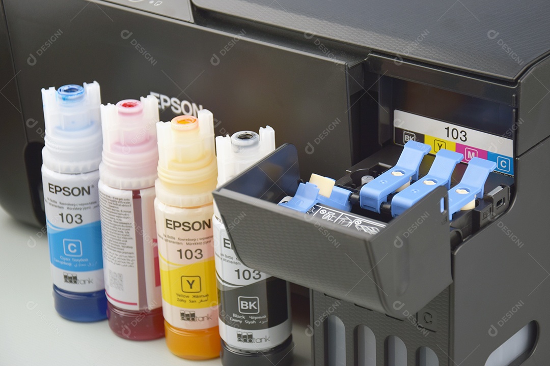 Quatro frascos de tinta Epson amarelo vermelho azul preto sobre fundo claro