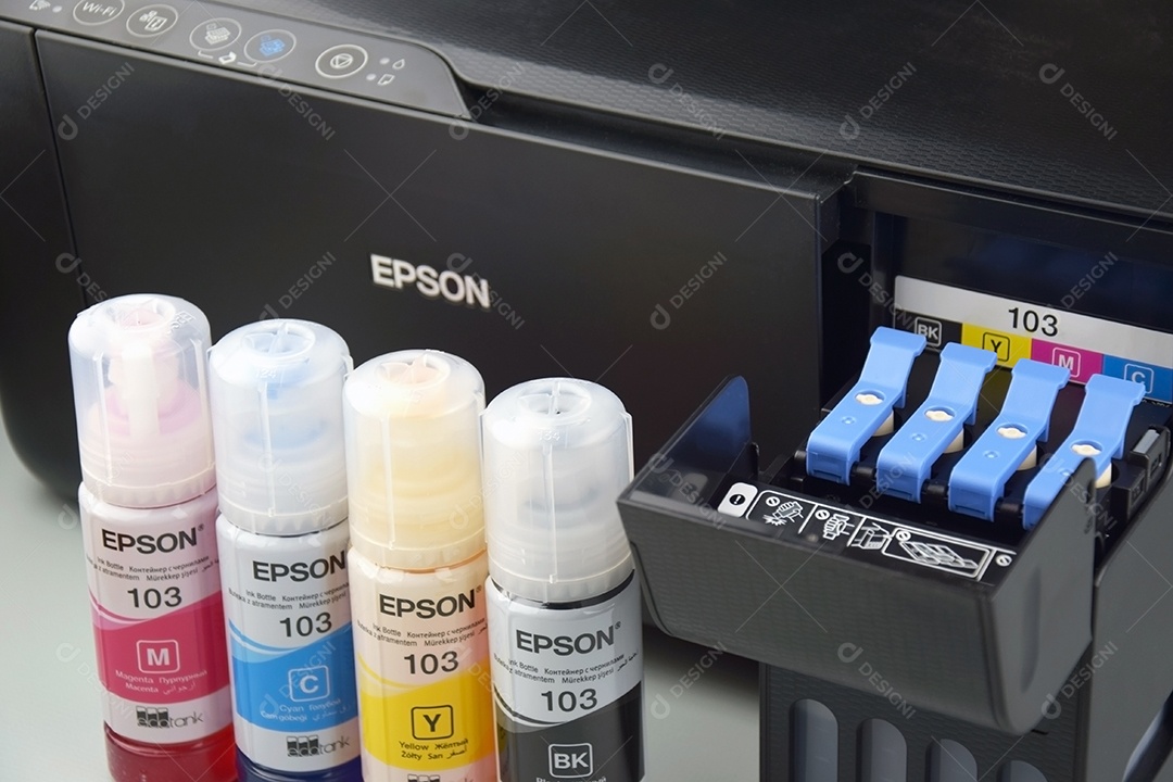 Quatro frascos de tinta Epson amarelo vermelho azul preto integrados a uma impressora