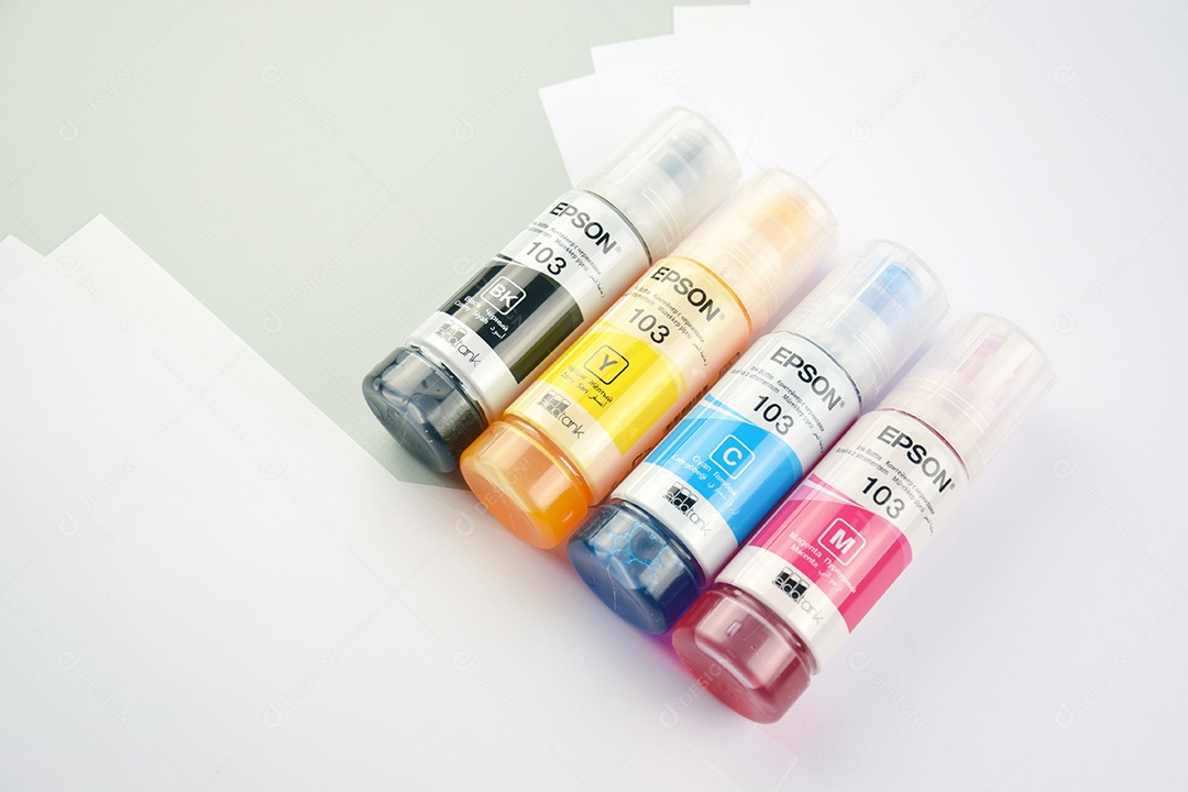 Quatro frascos de tinta Epson amarelo vermelho azul preto sobre fundo claro de duas cores