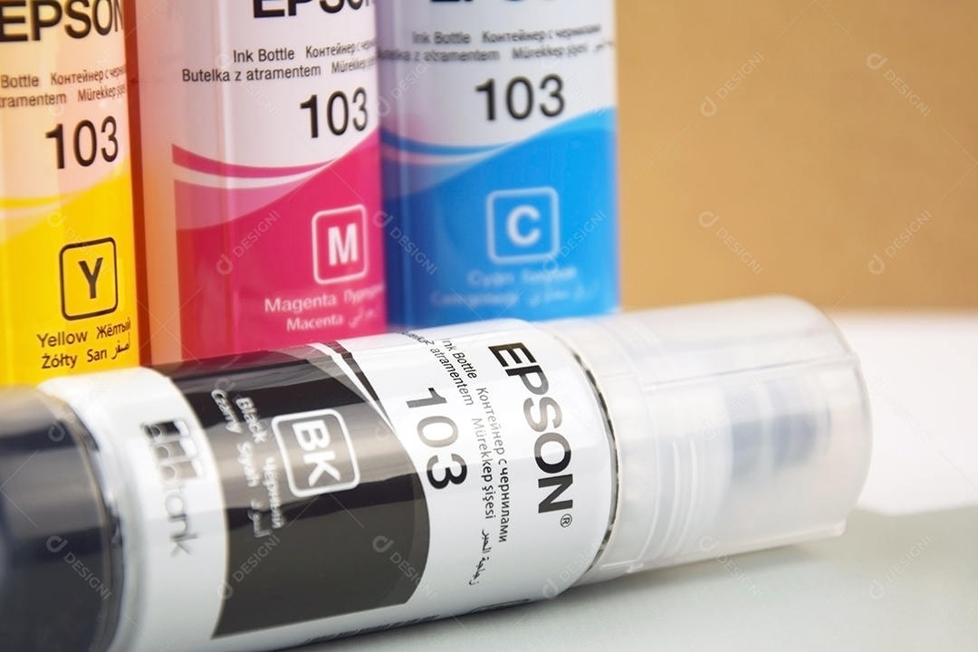 Quatro frascos de tinta Epson amarelo vermelho azul preto integrados a uma impressora