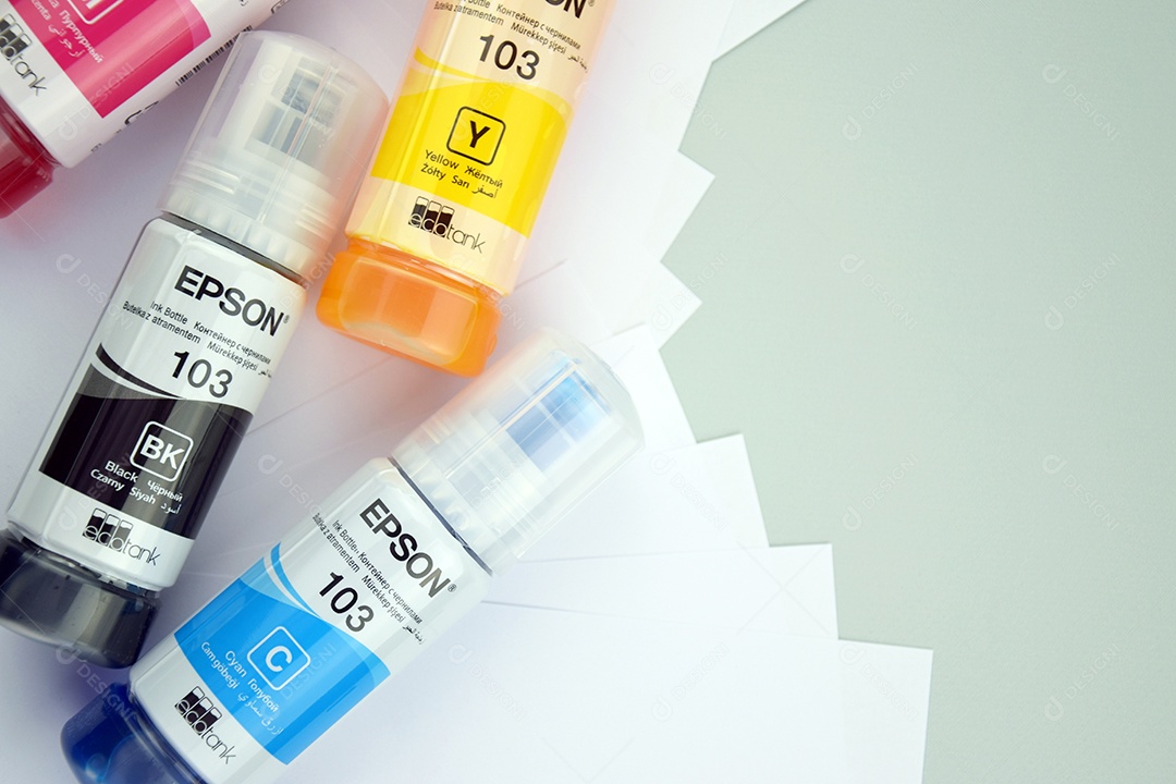 Quatro frascos de tinta Epson amarelo vermelho azul preto integrados a uma impressora