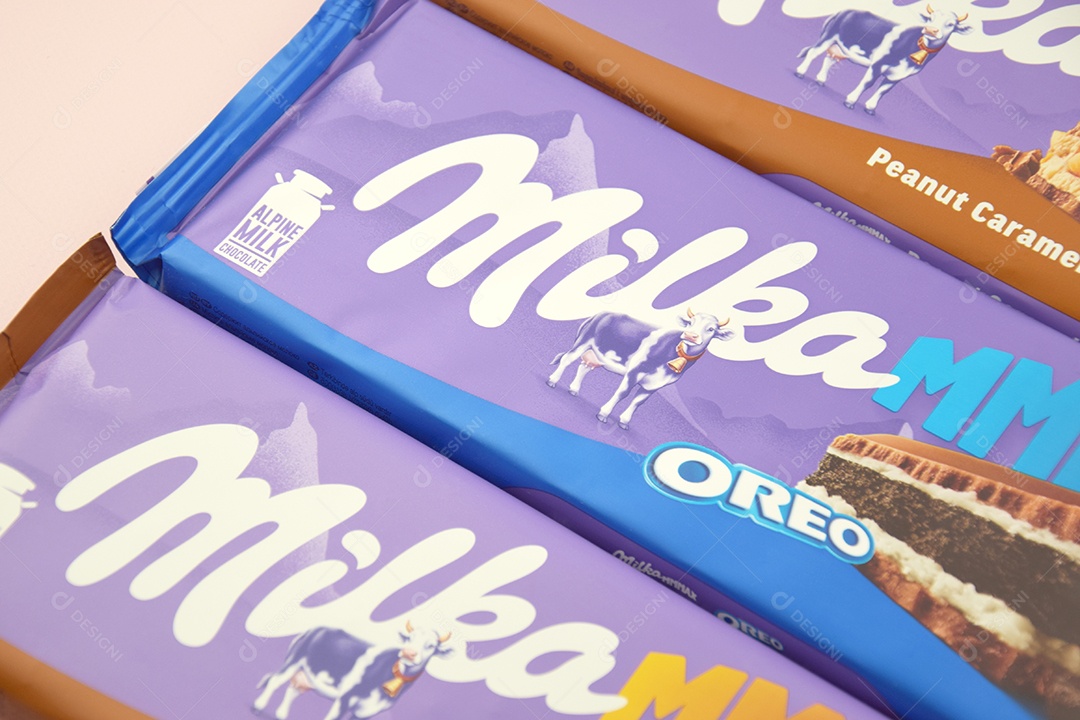 Marca de chocolate Milka com sabores Oreo e caramelo amendoim sobre fundo rosa suave