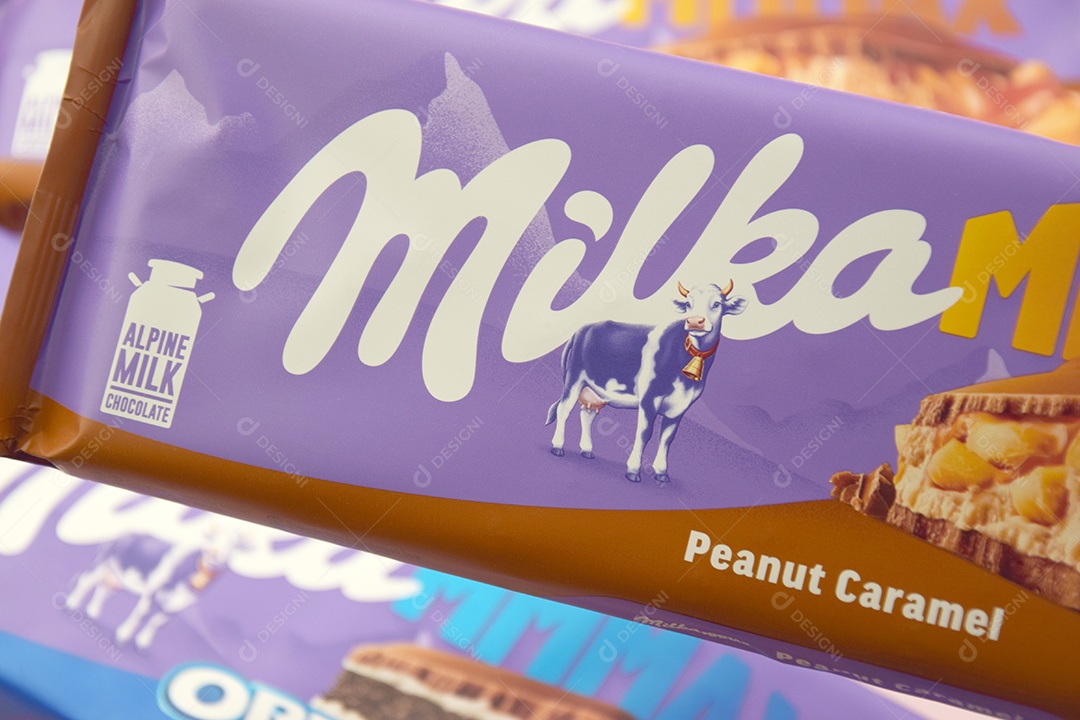 Marca de chocolate Milka com sabor Amendoim e caramelo sobre fundo rosa suave