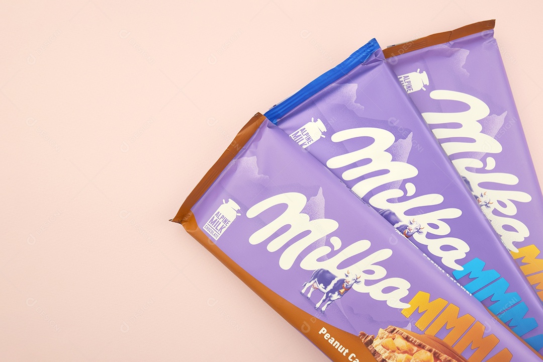 Marca de chocolate Milka com sabor Amendoim e caramelo sobre fundo rosa suave