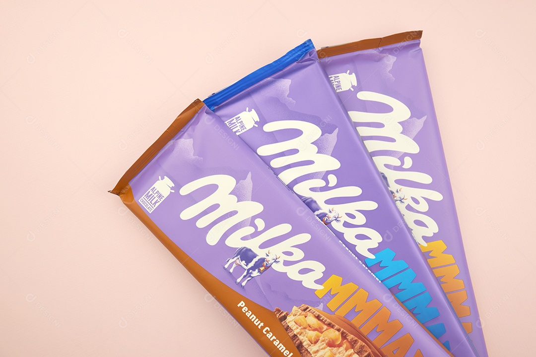 Marca de chocolate Milka com sabor Amendoim e caramelo sobre fundo rosa suave
