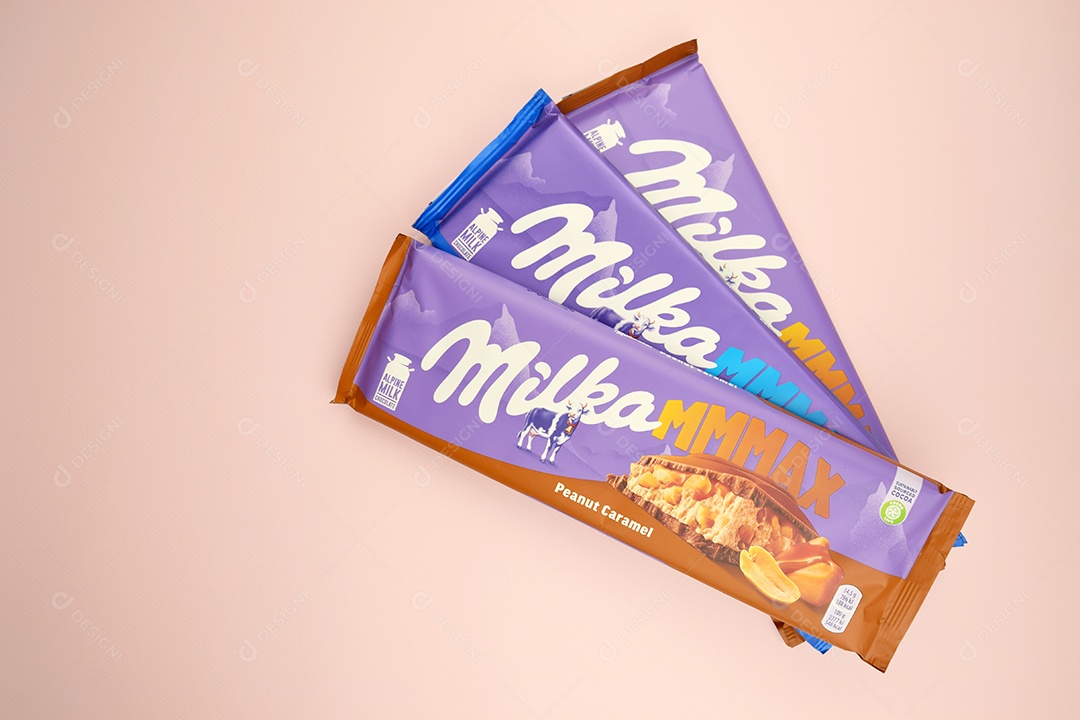 Marca de chocolate Milka com sabor Amendoim e caramelo sobre fundo rosa suave