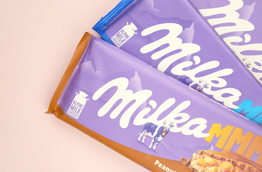 Marca de chocolate Milka com sabor Amendoim e caramelo sobre fundo rosa suave