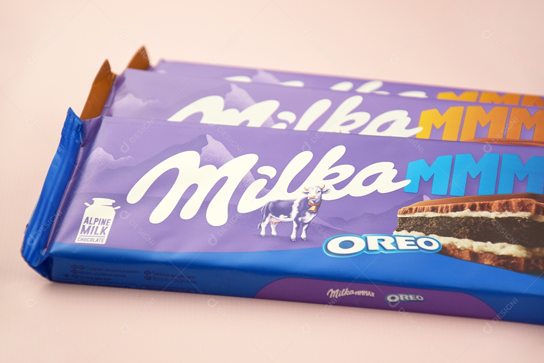 Marca de chocolate Milka com sabor Oreo e caramelo sobre fundo rosa suave