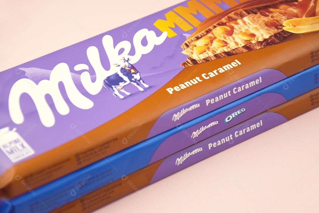 Marca de chocolate Milka com sabor Amendoim e caramelo sobre fundo rosa suave