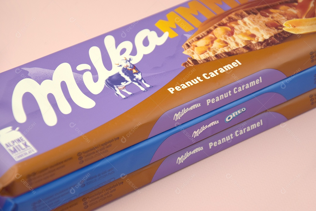 Marca de chocolate Milka com sabor Amendoim e caramelo sobre fundo rosa suave