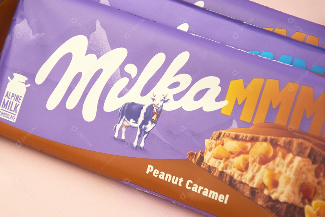Marca de chocolate Milka com sabor Amendoim e caramelo sobre fundo rosa suave