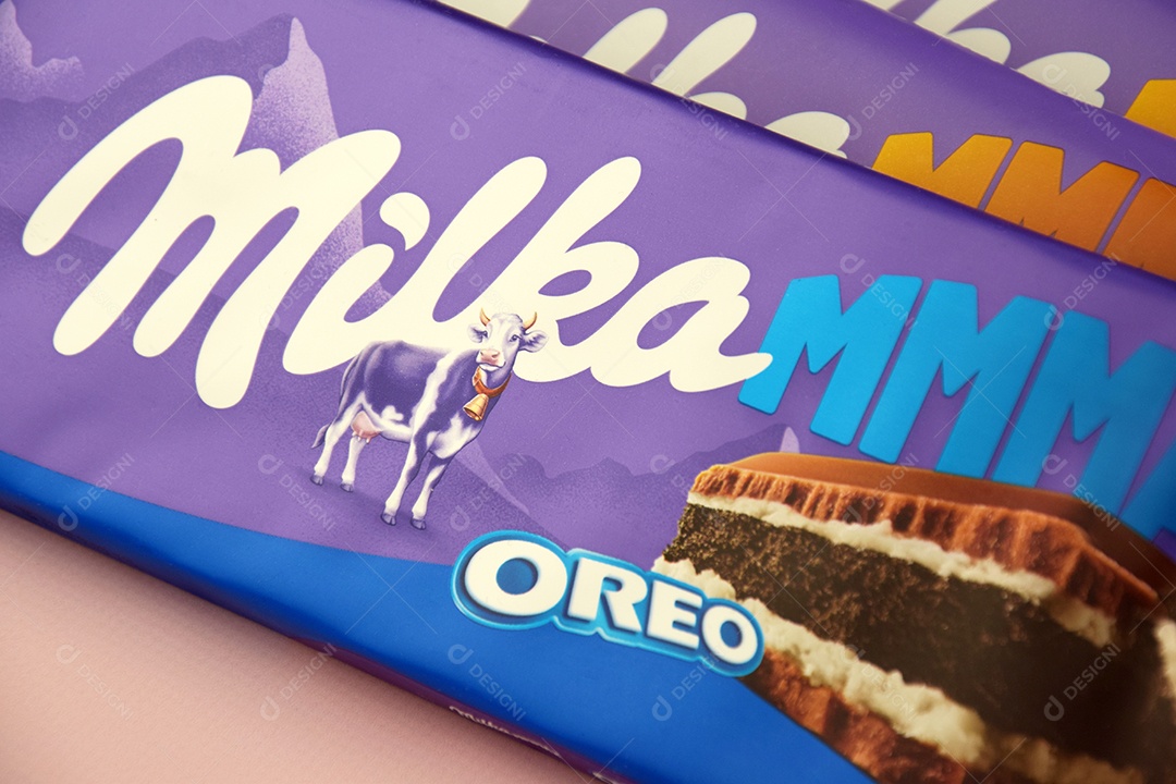 Marca de chocolate Milka com sabor Oreo e caramelo sobre fundo rosa suave