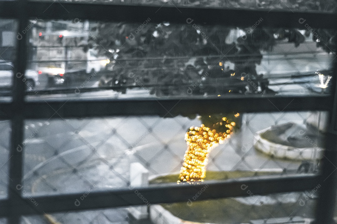 Pingos de chuva em vidro com árvore de Natal desfocada no fundo, luzes desfocadas, conceito de chuva