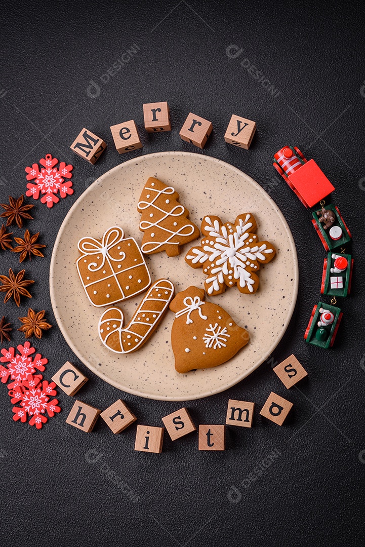 Lindos biscoitos de gengibre de Natal em uma placa cerâmica redonda sobre um fundo de concreto texturizado