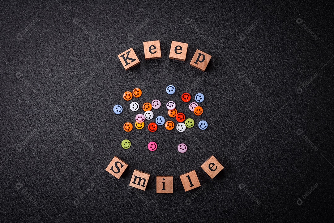 Conceito que consiste na inscrição da palavra sorriso, com emoticons redondos sobre fundo escuro de concreto. Pode ser usado como plano de fundo