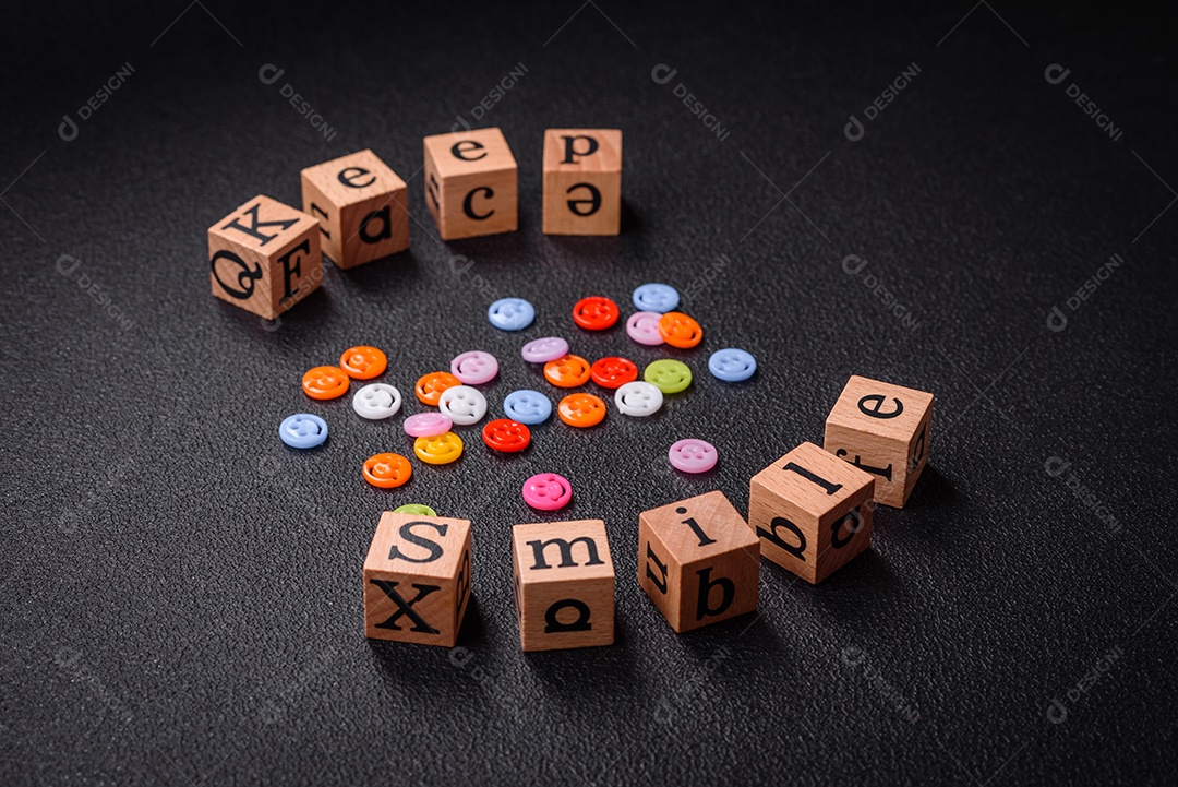 Conceito que consiste na inscrição da palavra sorriso, com emoticons redondos sobre fundo escuro de concreto. Pode ser usado como plano de fundo