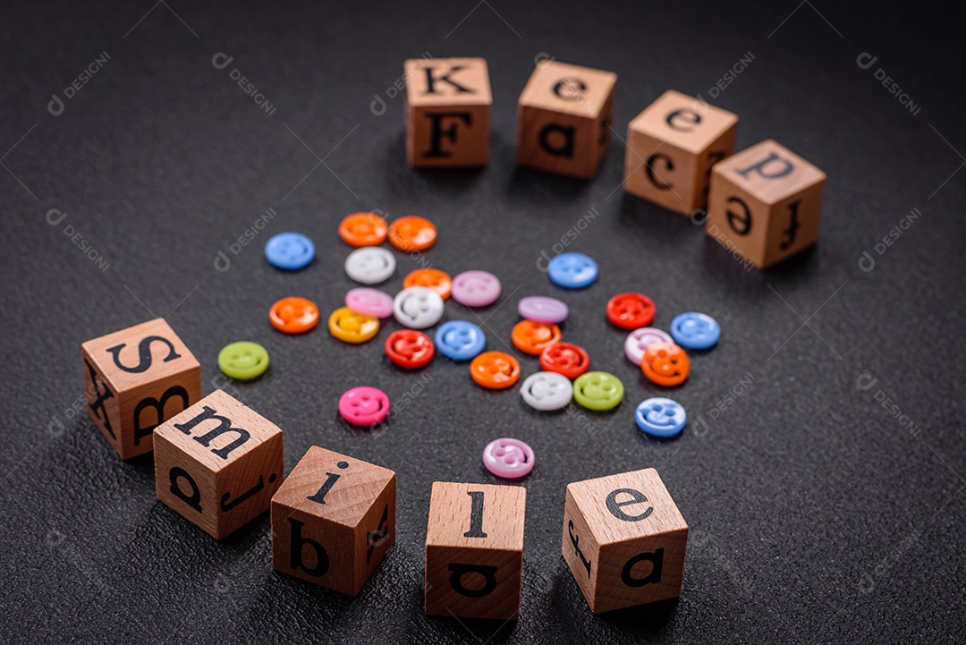 Conceito que consiste na inscrição da palavra sorriso, com emoticons redondos sobre fundo escuro de concreto. Pode ser usado como plano de fundo