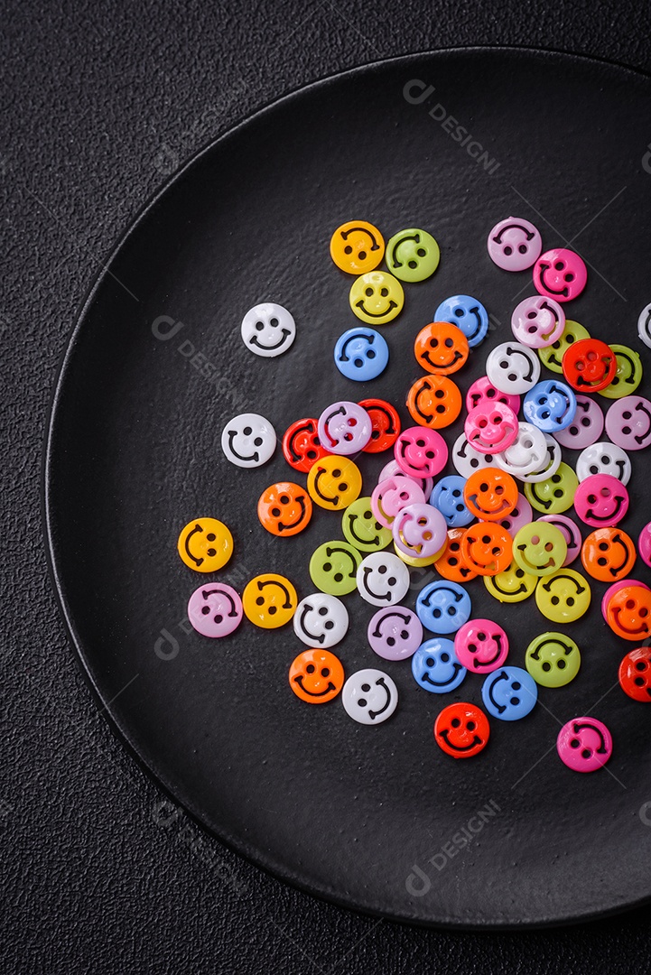 Conceito que consiste na inscrição da palavra sorriso, com emoticons redondos sobre fundo escuro de concreto. Pode ser usado como plano de fundo