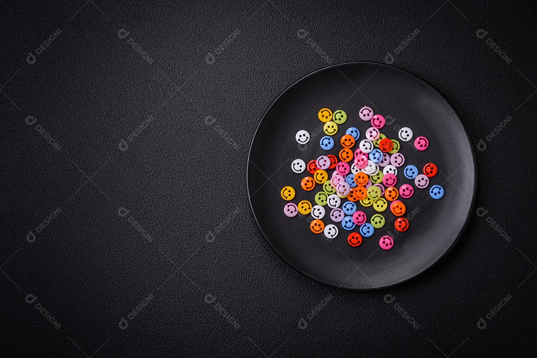 Conceito que consiste na inscrição da palavra sorriso, com emoticons redondos sobre fundo escuro de concreto. Pode ser usado como plano de fundo