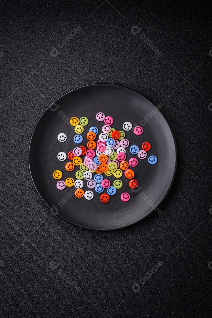 Conceito que consiste na inscrição da palavra sorriso, com emoticons redondos sobre fundo escuro de concreto. Pode ser usado como plano de fundo