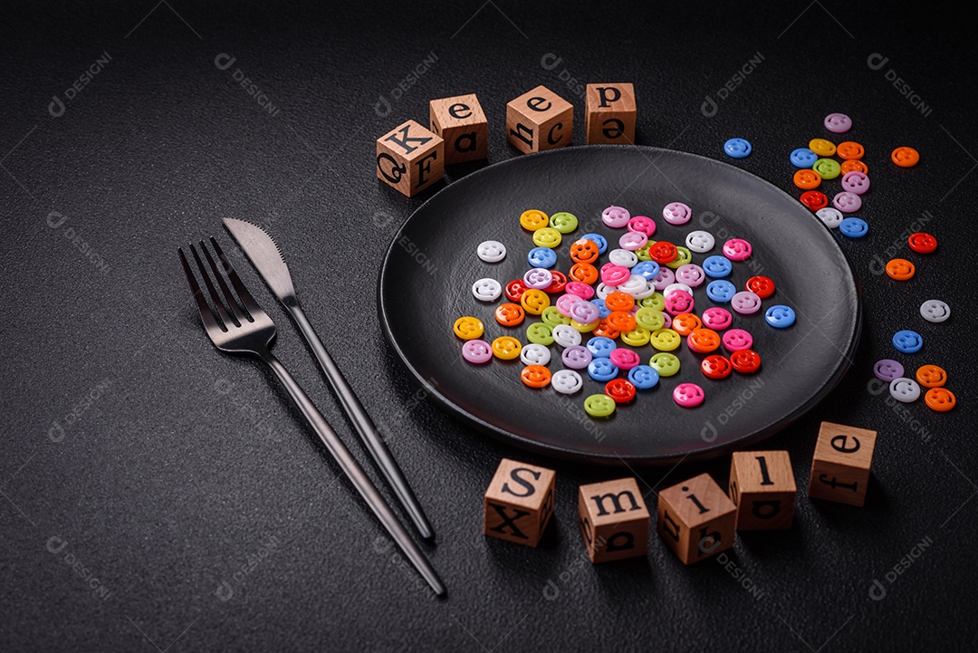 Conceito que consiste na inscrição da palavra sorriso, com emoticons redondos sobre fundo escuro de concreto. Pode ser usado como plano de fundo