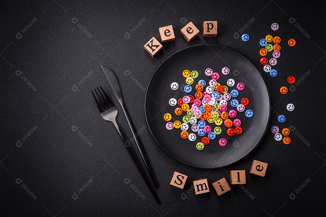 Conceito que consiste na inscrição da palavra sorriso, com emoticons redondos sobre fundo escuro de concreto. Pode ser usado como plano de fundo