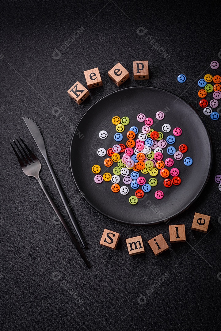 Conceito que consiste na inscrição da palavra sorriso, com emoticons redondos sobre fundo escuro de concreto. Pode ser usado como plano de fundo