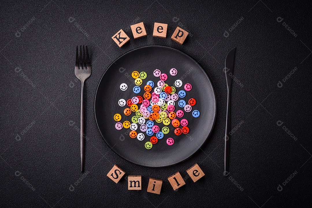 Conceito que consiste na inscrição da palavra sorriso, com emoticons redondos sobre fundo escuro de concreto. Pode ser usado como plano de fundo