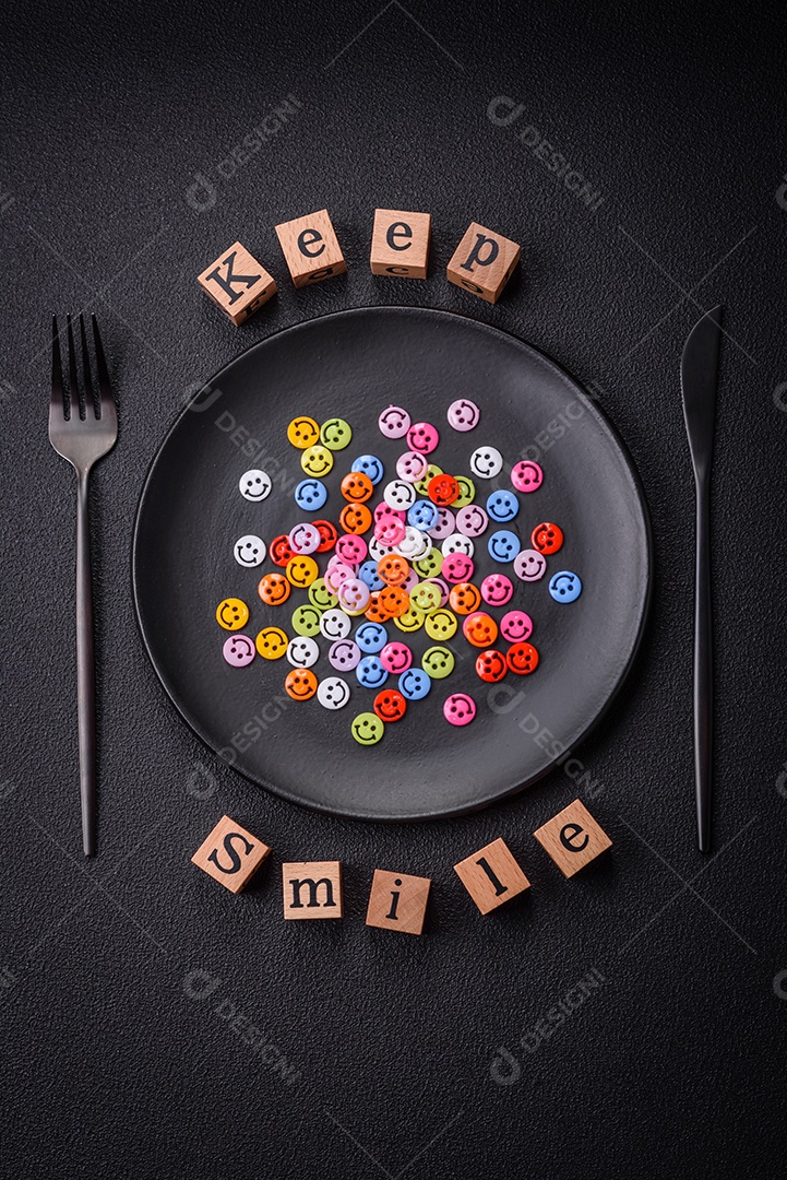 Conceito que consiste na inscrição da palavra sorriso, com emoticons redondos sobre fundo escuro de concreto. Pode ser usado como plano de fundo