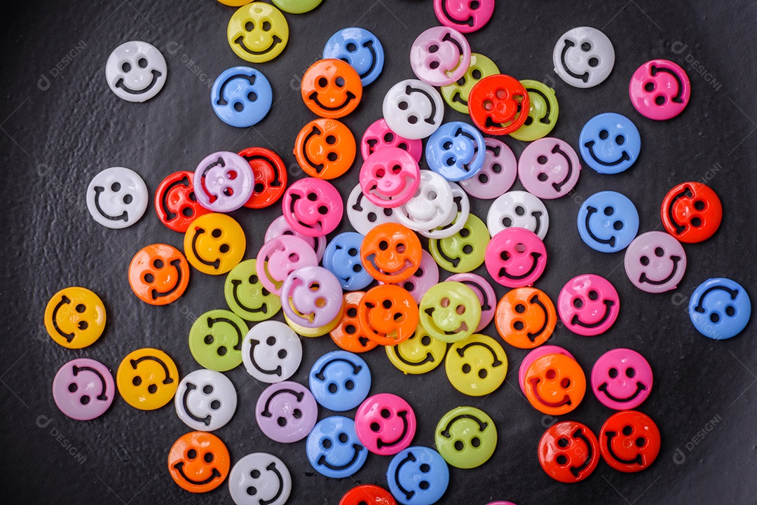 Conceito que consiste na inscrição da palavra sorriso, com emoticons redondos sobre fundo escuro de concreto. Pode ser usado como plano de fundo