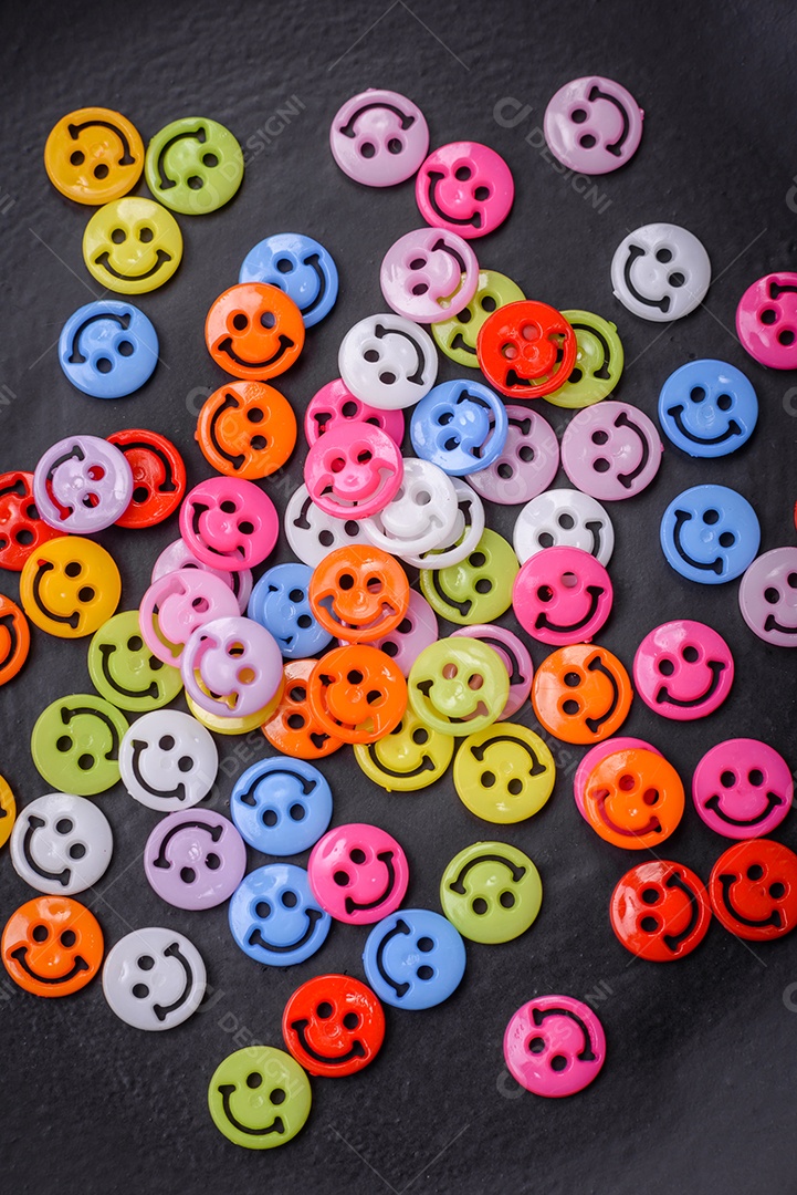 Conceito que consiste na inscrição da palavra sorriso, com emoticons redondos sobre fundo escuro de concreto. Pode ser usado como plano de fundo