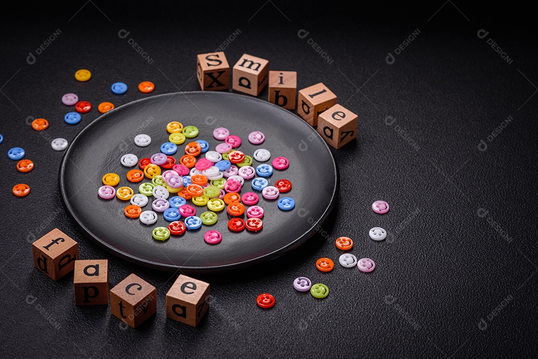 Conceito que consiste na inscrição da palavra sorriso, com emoticons redondos sobre fundo escuro de concreto. Pode ser usado como plano de fundo