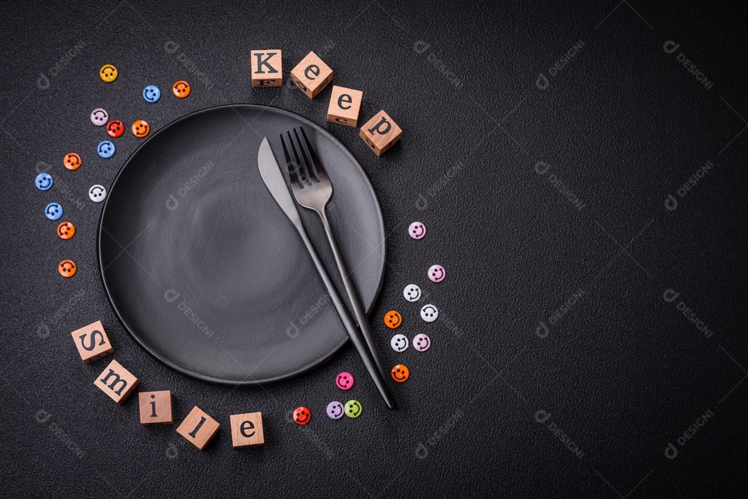 Conceito que consiste na inscrição da palavra sorriso, com emoticons redondos sobre fundo escuro de concreto. Pode ser usado como plano de fundo