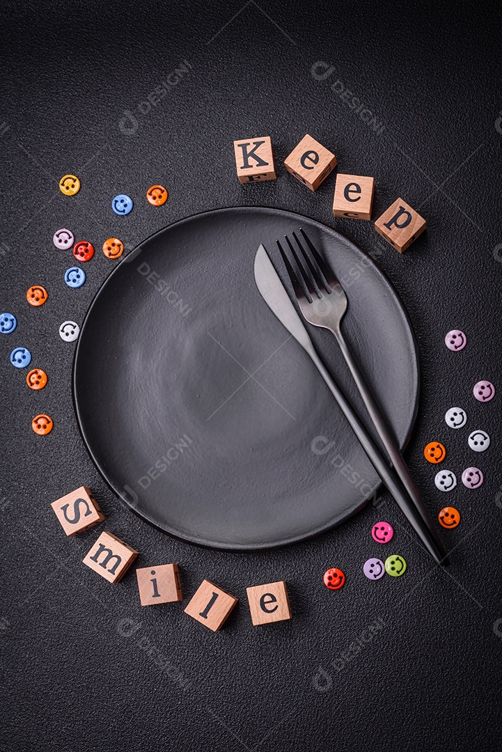 Conceito que consiste na inscrição da palavra sorriso, com emoticons redondos sobre fundo escuro de concreto. Pode ser usado como plano de fundo