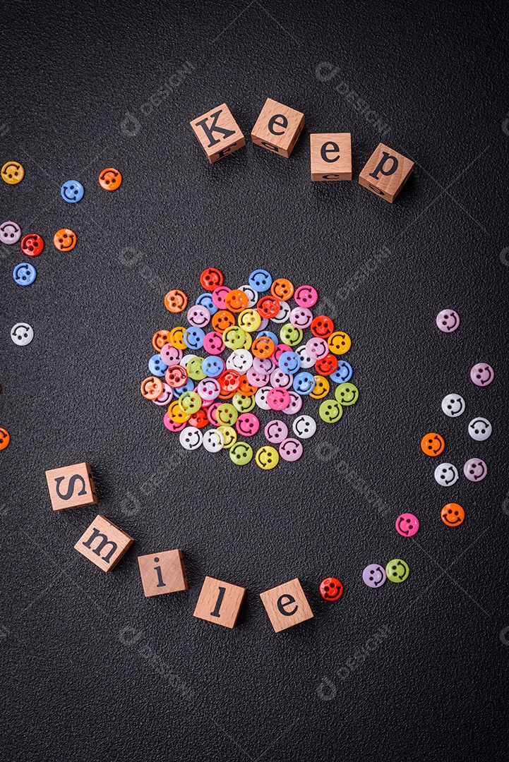 Conceito que consiste na inscrição da palavra sorriso, com emoticons redondos sobre fundo escuro de concreto. Pode ser usado como plano de fundo