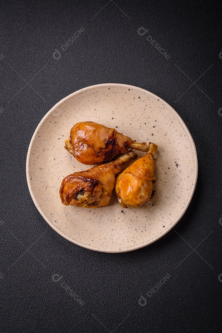 Delicioso prato asiático com pernas de frango em molho teriyaki com sal e especiarias sobre um fundo escuro de concreto