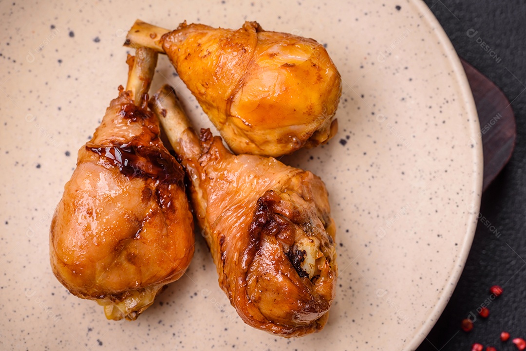 Delicioso prato asiático com pernas de frango em molho teriyaki com sal e especiarias sobre um fundo escuro de concreto