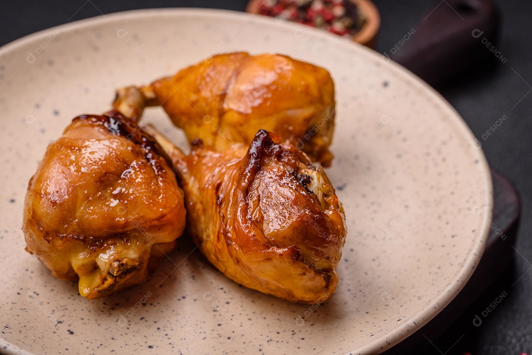 Delicioso prato asiático com pernas de frango em molho teriyaki com sal e especiarias sobre um fundo escuro de concreto