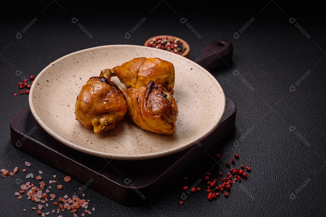 Delicioso prato asiático com pernas de frango em molho teriyaki com sal e especiarias sobre um fundo escuro de concreto