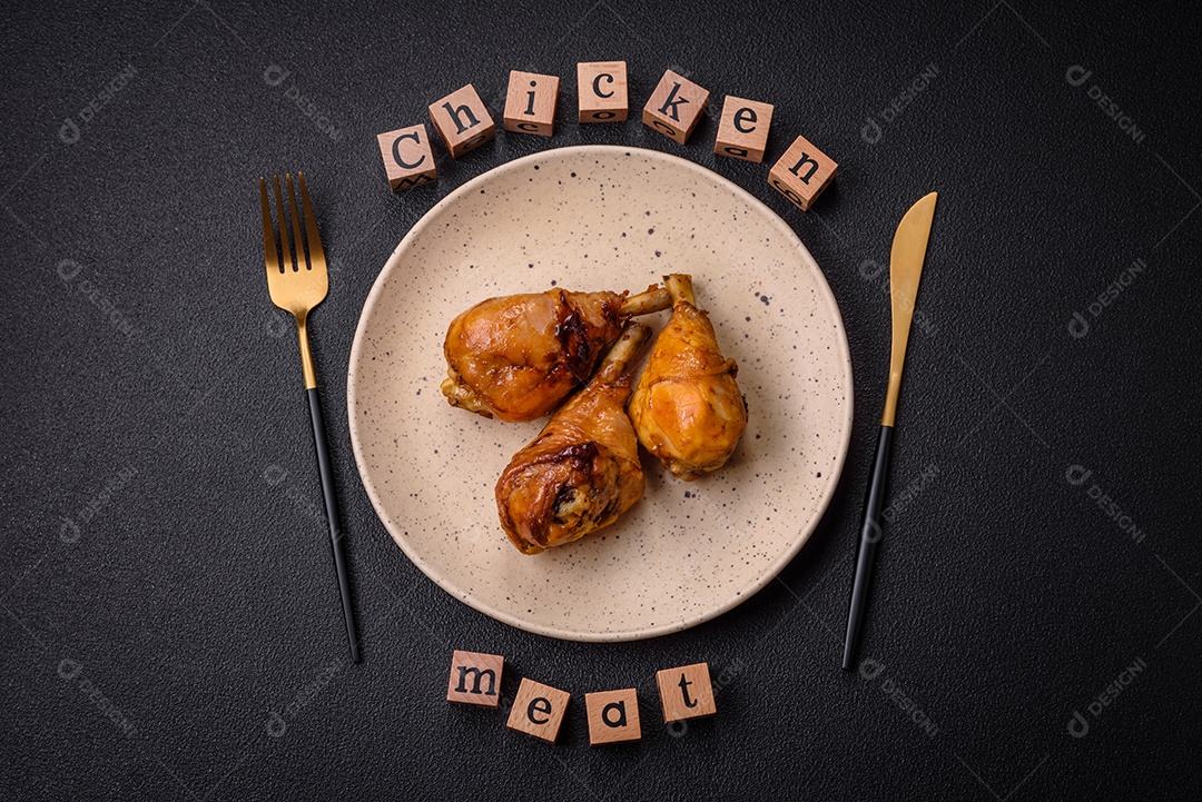 Delicioso prato asiático com pernas de frango em molho teriyaki com sal e especiarias sobre um fundo escuro de concreto