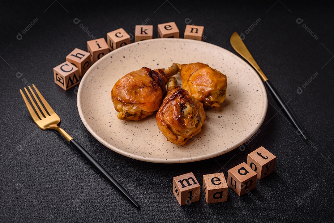 Delicioso prato asiático com pernas de frango em molho teriyaki com sal e especiarias sobre um fundo escuro de concreto